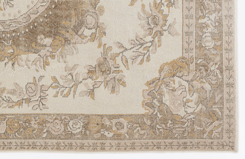 Load image 1 in gallery view. Cream and tan rug with a distressed floral medallion pattern and a decorative border.