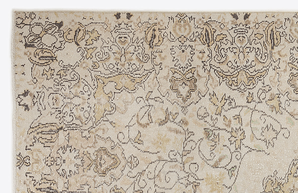 Beige and taupe traditional rug with a distressed, intricate floral medallion pattern on a white background.