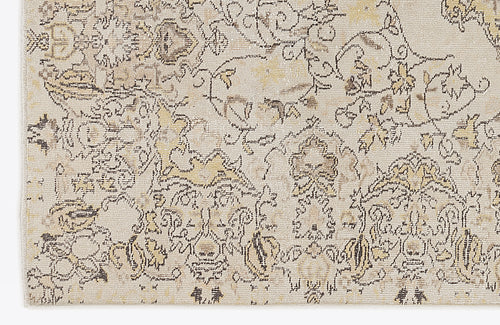 Load image 1 in gallery view. Beige and cream rug with a distressed, traditional floral medallion pattern in charcoal and muted gold.