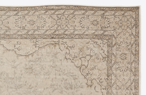 Load image 1 in gallery view. Beige and taupe vintage-style rug with a distressed floral medallion border and geometric corner detail.