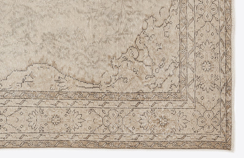 Load image 1 in gallery view. Beige and taupe distressed rug with a traditional floral medallion border and faded central pattern.