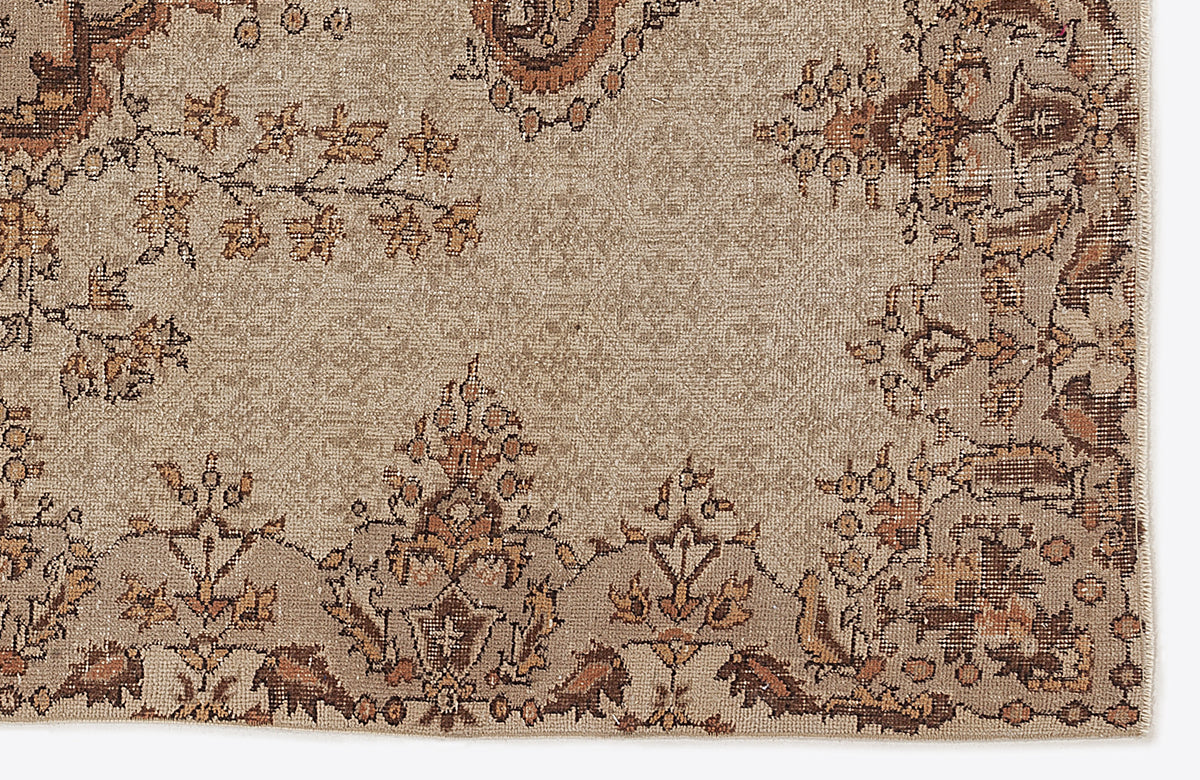 Beige and brown rug with a distressed traditional floral medallion pattern on a white background.