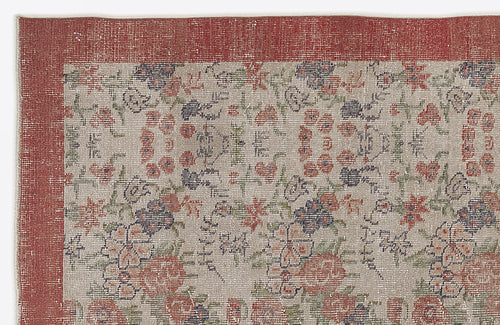 Load image 1 in gallery view. Distressed beige rug with a red border and a multi-colored floral pattern in red, green, and dark blue.