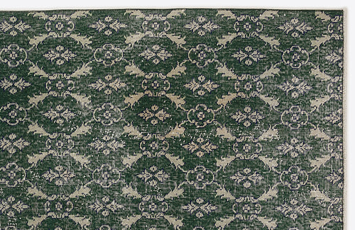 Load image 1 in gallery view. Dark green rug with a repeating beige floral medallion pattern and distressed texture on a white background.