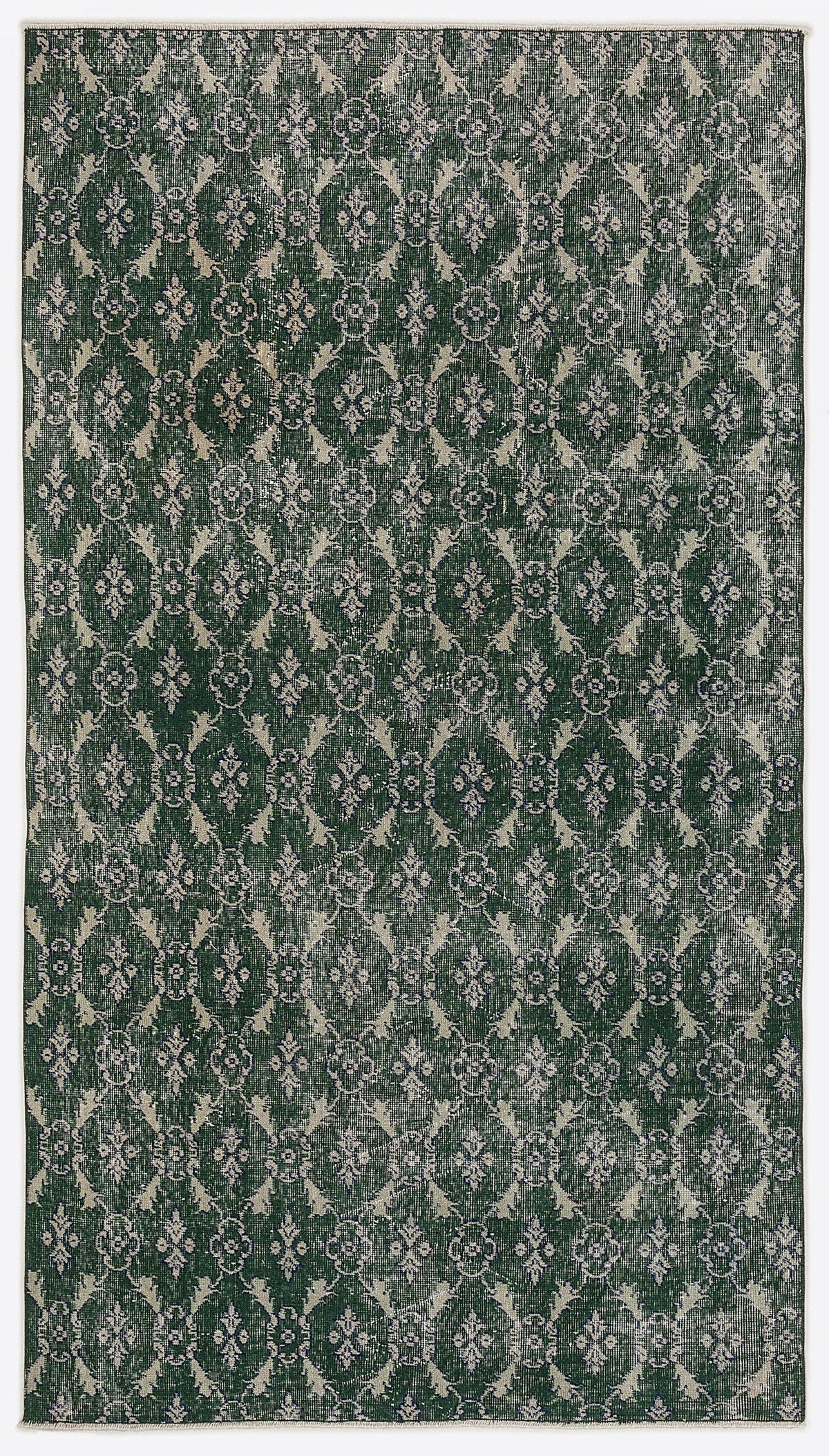 Dark green and cream distressed rug featuring a repeating damask-inspired trellis pattern.