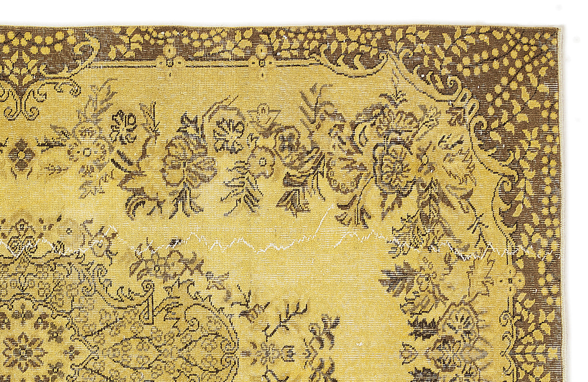 Mustard yellow and dark brown vintage-style rug with a detailed floral medallion pattern and ornate border.
