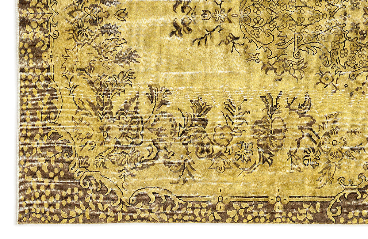 Mustard yellow and dark brown rug with a distressed traditional floral medallion pattern.