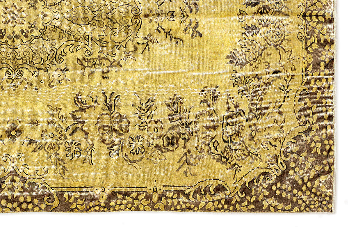 Mustard yellow and brown distressed rug with a traditional floral medallion pattern and ornate border.