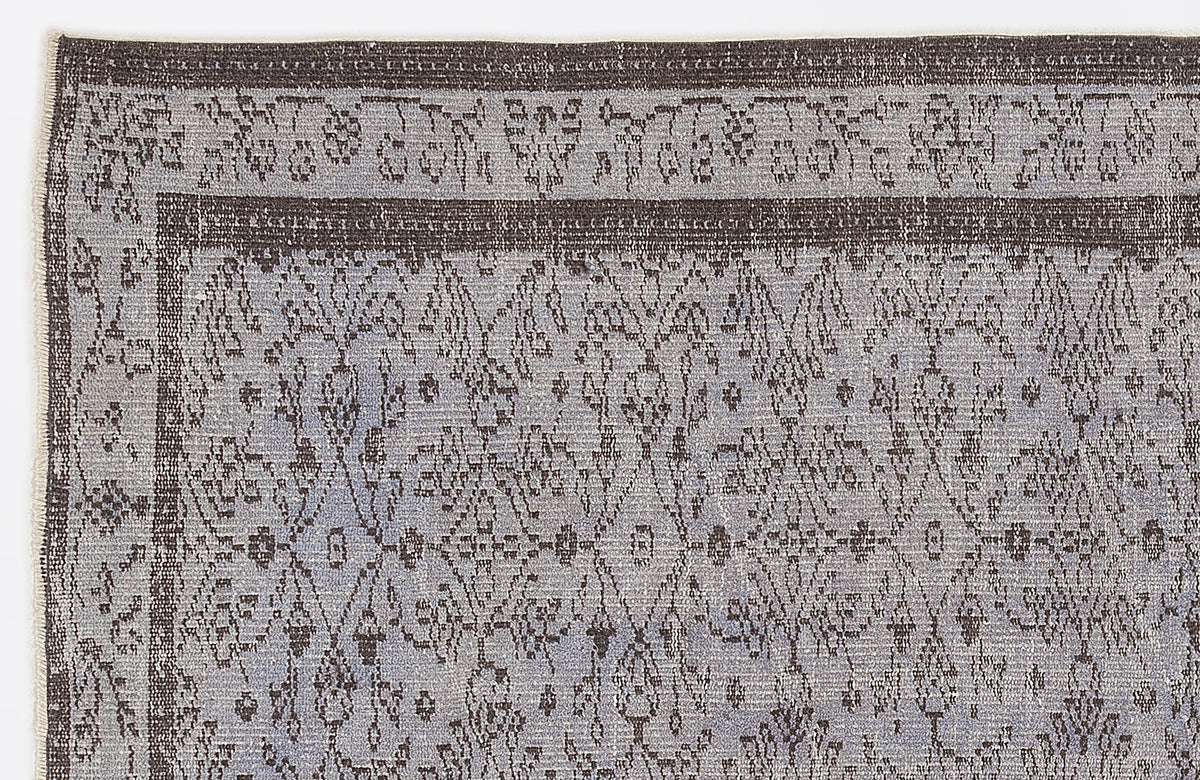 Grey and charcoal rug with a distressed, traditional medallion pattern and a wide decorative border.