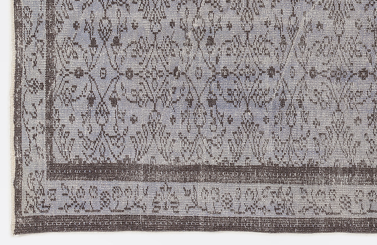 Blue and charcoal grey rug with a distressed traditional medallion pattern and a wide decorative border.