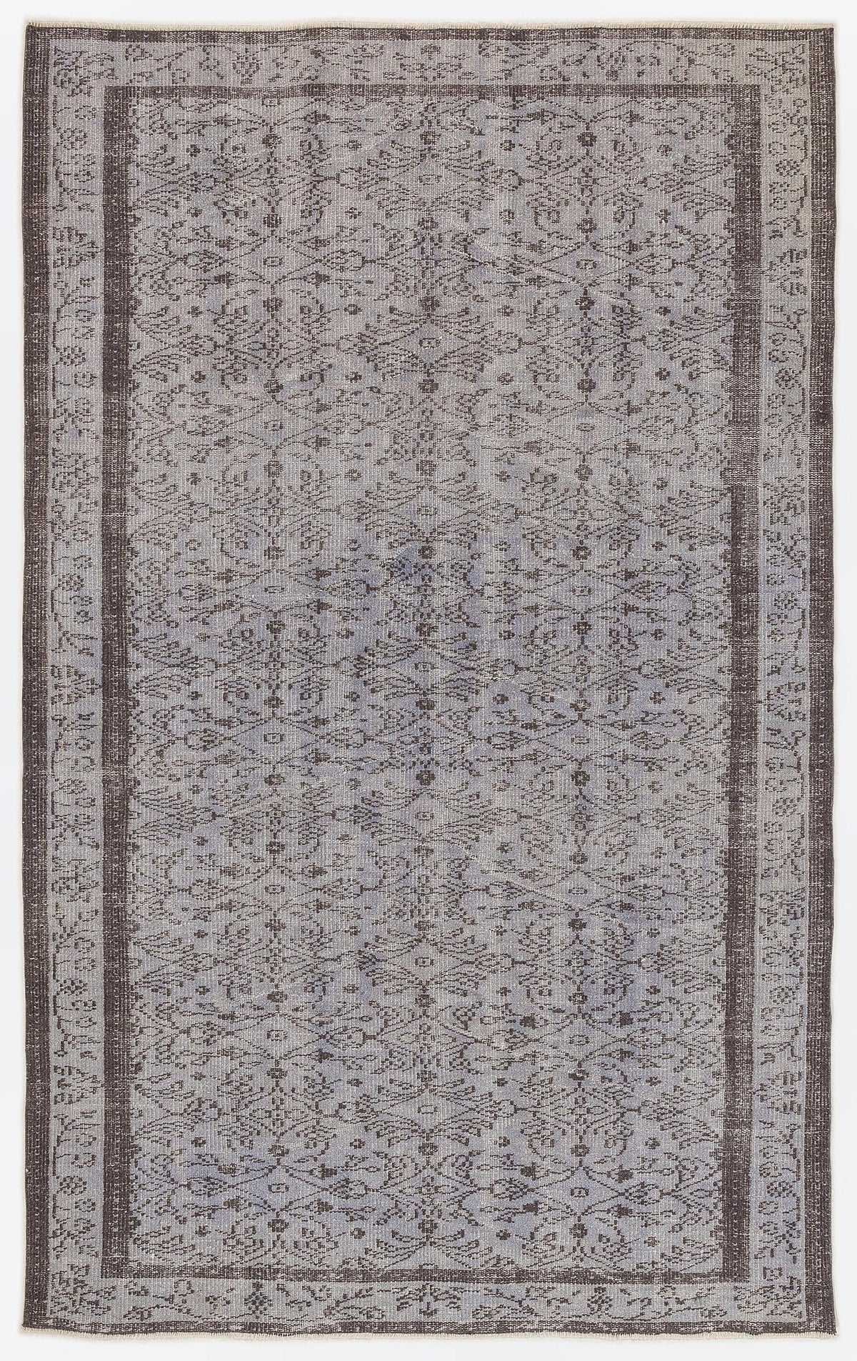 Grey and charcoal vintage-style rug with a distressed floral medallion pattern and a wide decorative border.
