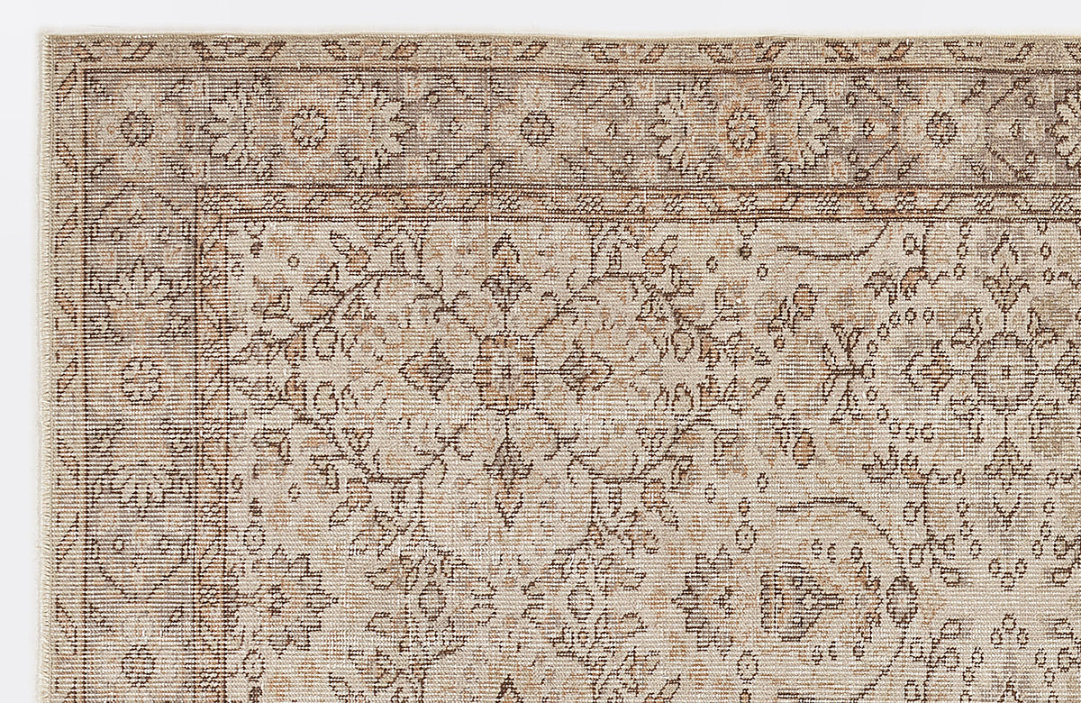 Beige and brown rug with a distressed traditional floral medallion pattern and a detailed border.