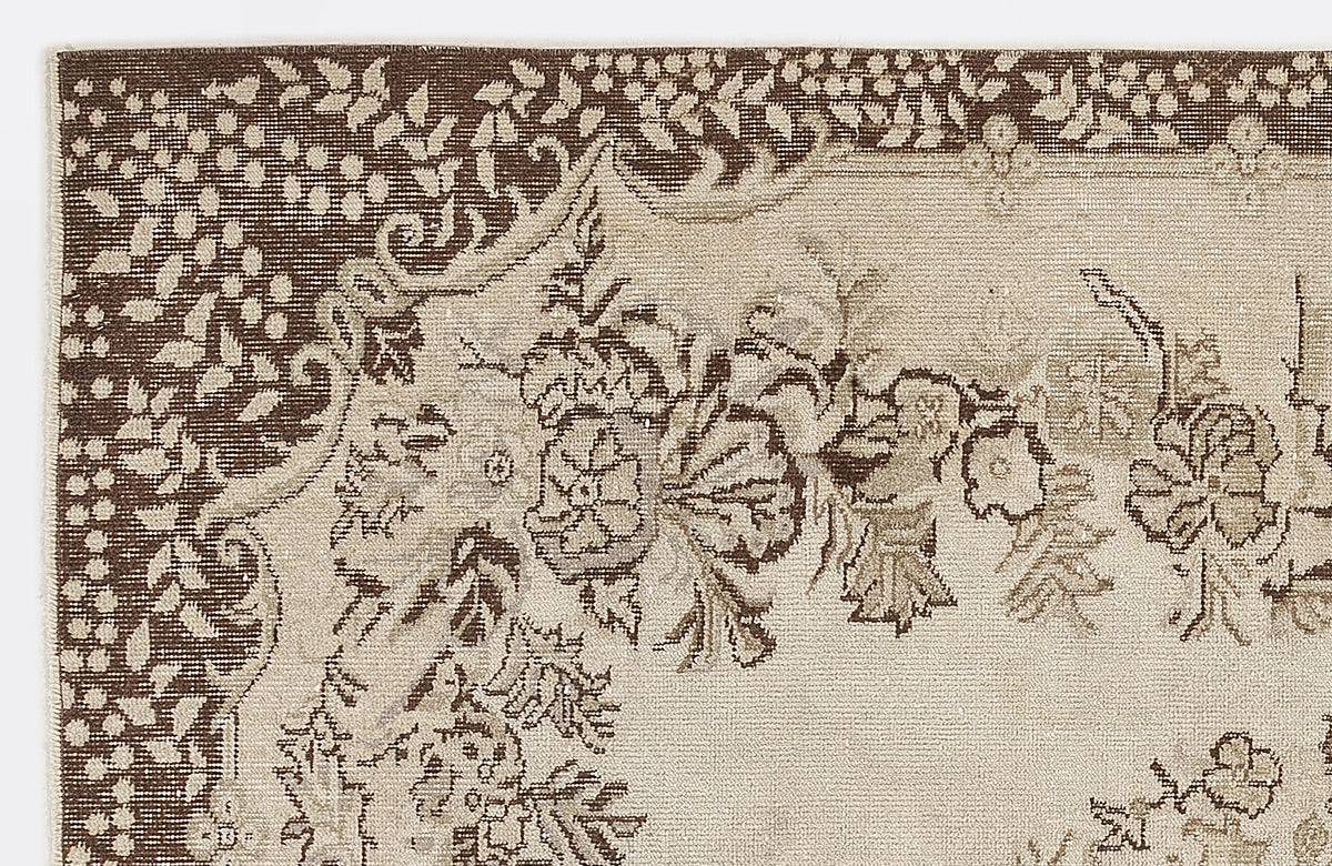 Beige and brown rug with a traditional floral medallion pattern and a detailed decorative border.