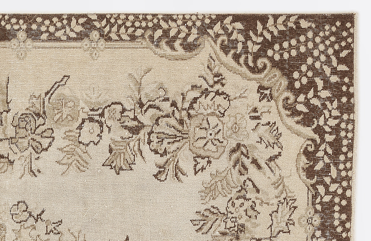 Beige and dark brown rug with a traditional floral medallion border and intricate botanical motifs.