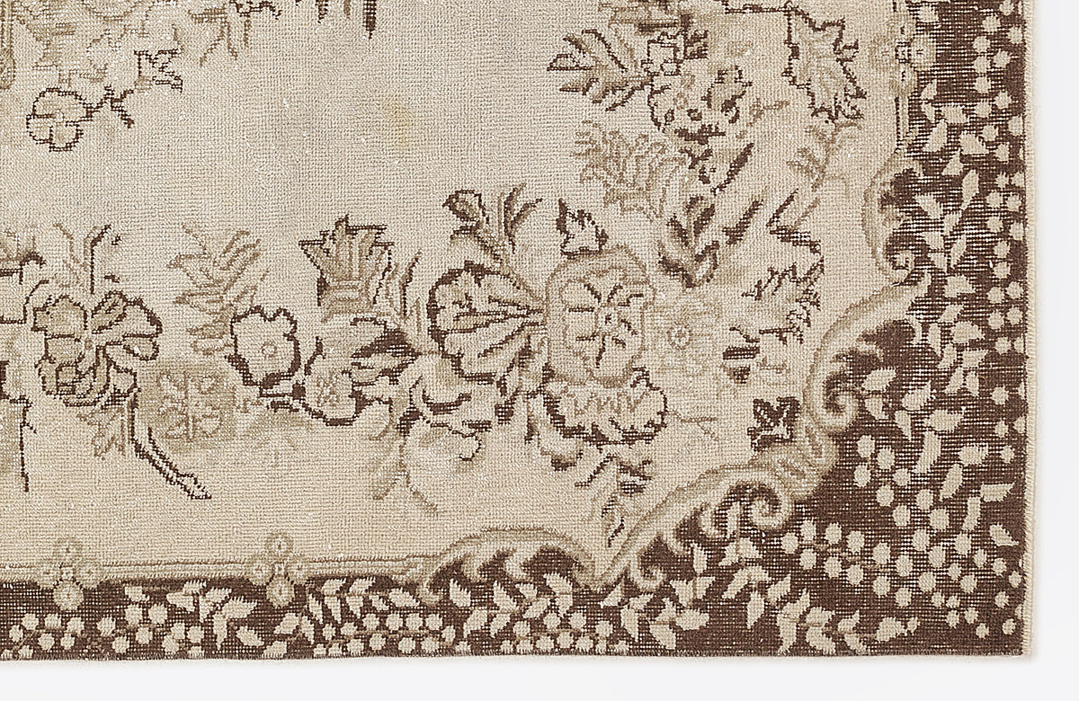 Beige and brown rug with a traditional floral medallion pattern and a detailed botanical border.
