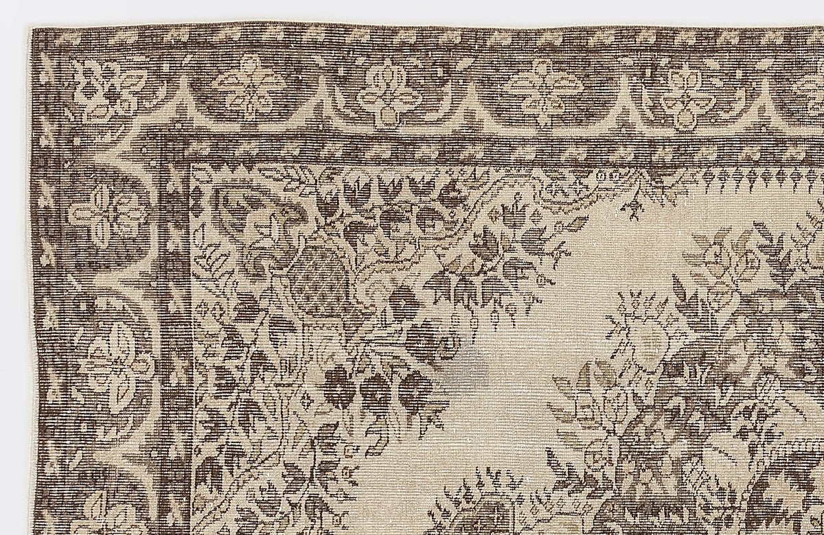 Dark brown and beige rug with a traditional floral medallion pattern and ornate border on a white background.