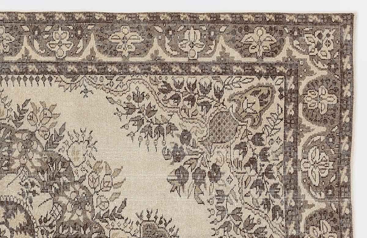 Dark brown and cream rug with a traditional floral medallion pattern and a detailed geometric border.