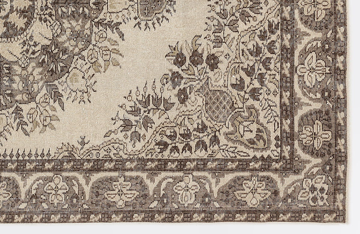 Beige and dark brown rug with a traditional floral medallion pattern and a detailed decorative border.