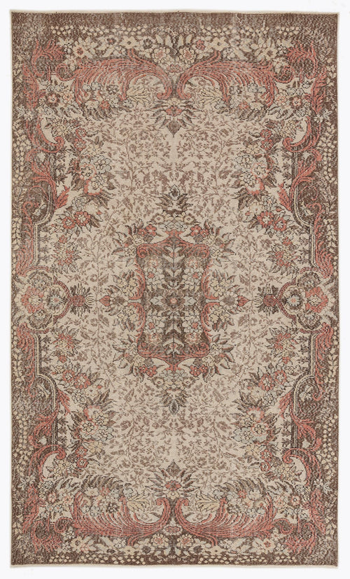 Load image 1 in gallery view. Brown and cream traditional rug with a distressed floral medallion pattern and coral-toned accents.