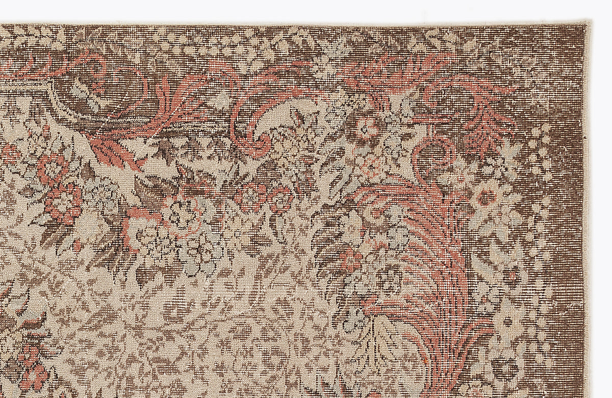 Brown, beige, and terracotta traditional floral medallion rug with a distressed, weathered texture.