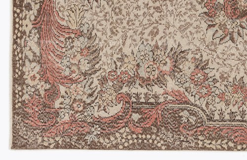 Load image 1 in gallery view. Close-up of a traditional rug with a distressed floral medallion pattern in shades of brown, cream, and muted coral.