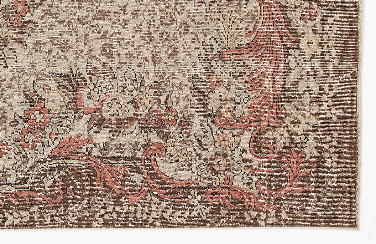 Brown, beige, and terracotta floral medallion rug with a distressed, traditional pattern on a white background.
