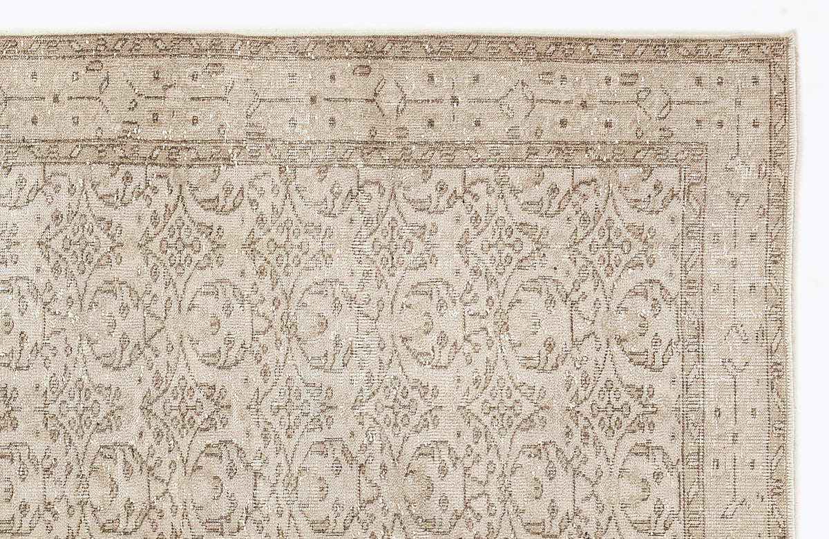 Beige and taupe traditional rug with a distressed floral medallion pattern and a decorative border.