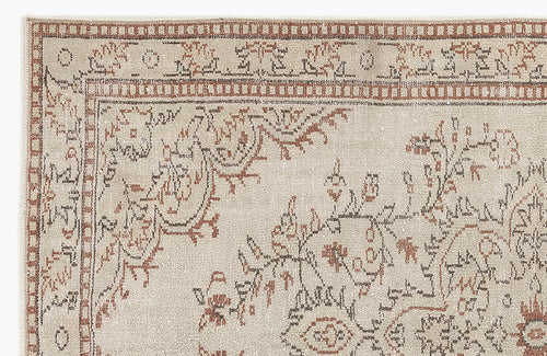Load image 1 in gallery view. Beige rug with a distressed terracotta and charcoal floral medallion pattern and a geometric border.