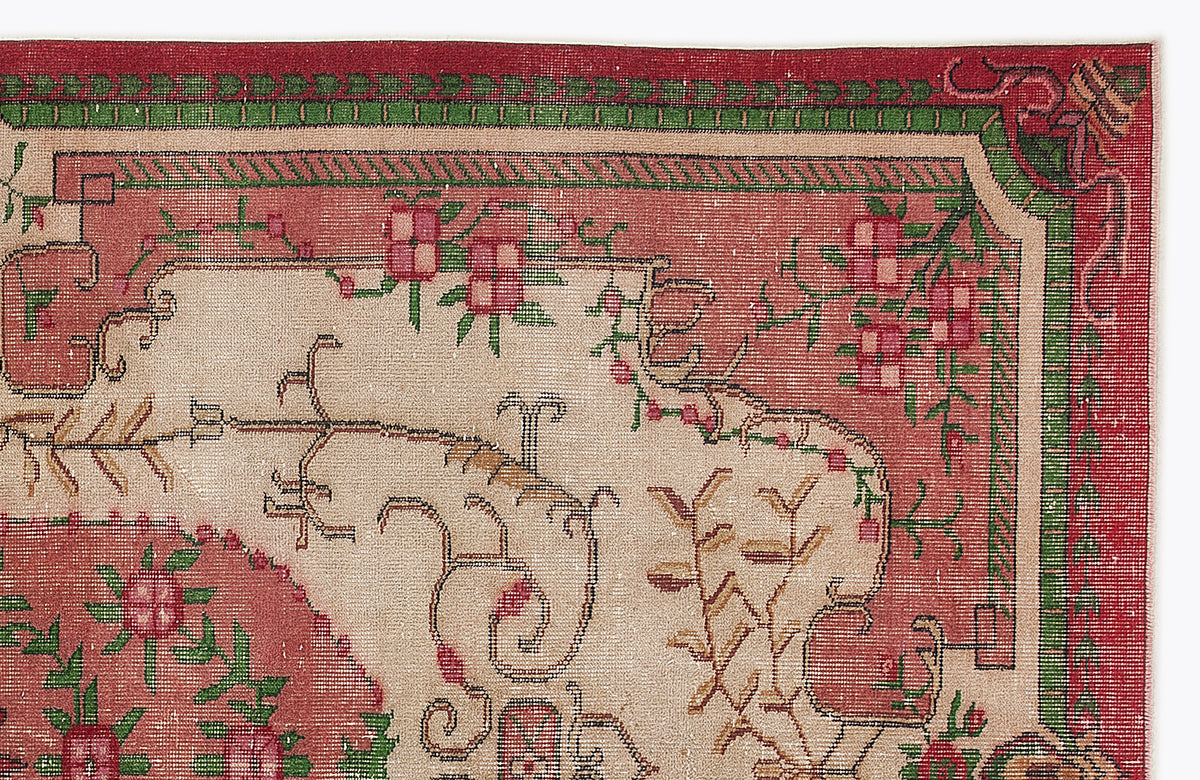 Traditional rug with a beige field, red borders, and green geometric accents featuring floral and vine motifs.