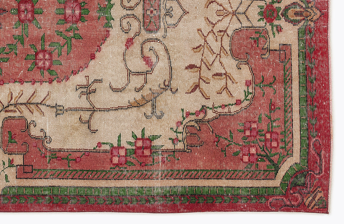 Beige, red, and green traditional rug with a floral medallion pattern and a geometric border.