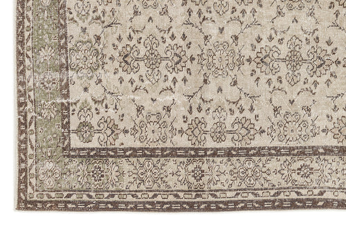 Load image 1 in gallery view. Beige and sage green vintage-style rug with a distressed floral medallion pattern and a dark brown geometric border.