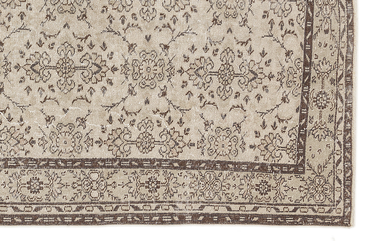 Beige and brown traditional rug with a distressed floral medallion pattern and a detailed geometric border.