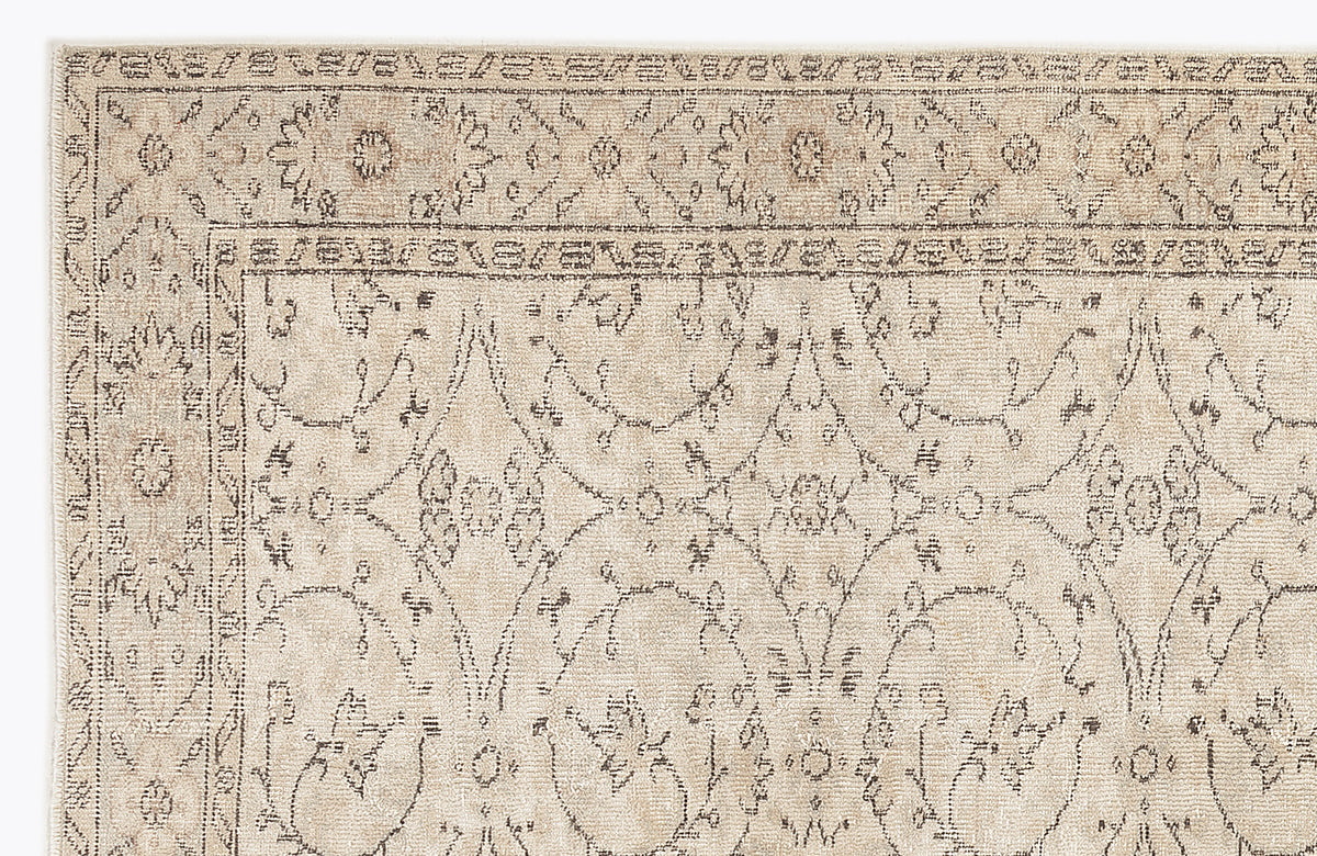 Beige and taupe rug with a distressed traditional floral medallion pattern and a decorative border.