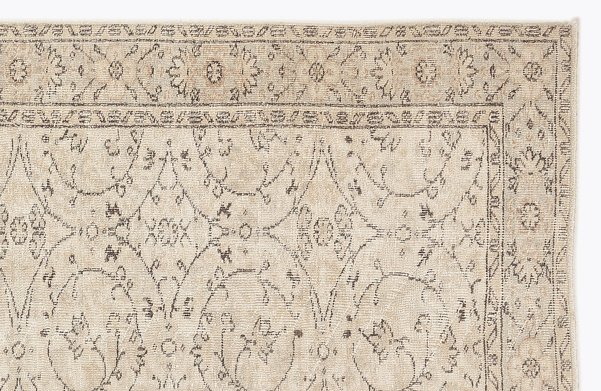 Beige rug with a dark grey traditional floral medallion pattern and a detailed border on a white background.