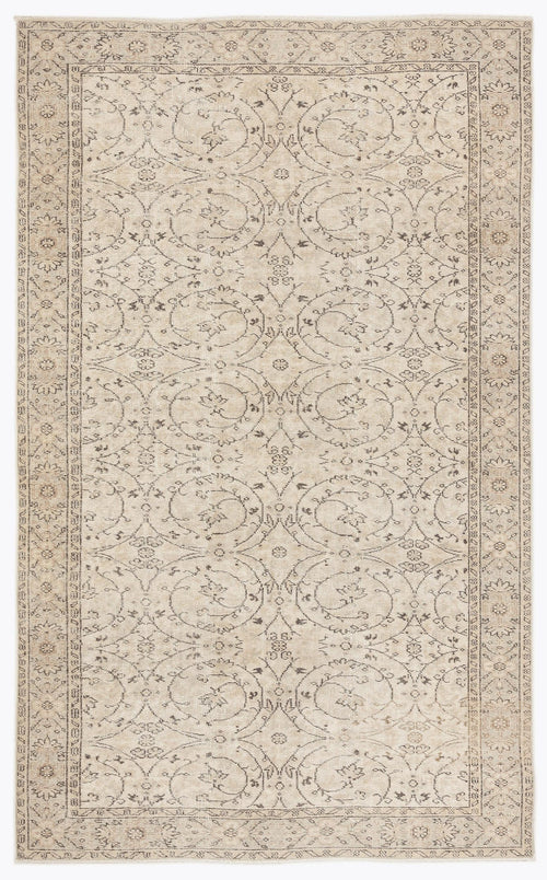 Load image 1 in gallery view. Beige and charcoal grey area rug with a repeating floral medallion pattern and a decorative border.