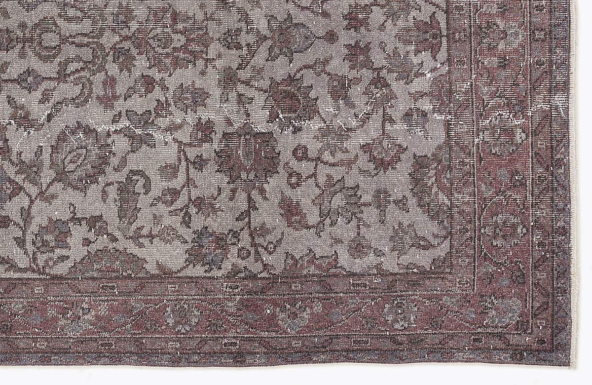 Distressed grey and burgundy rug with a traditional floral pattern and a wide decorative border.
