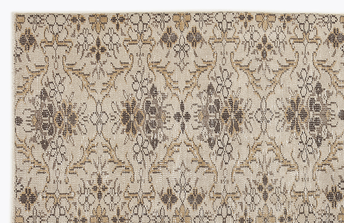 Beige rug with a repeating dark brown and tan floral medallion pattern on a textured, neutral background.