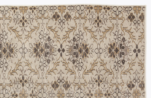 Load image 1 in gallery view. Beige rug with a repeating dark brown and tan floral medallion pattern in a distressed, vintage style.