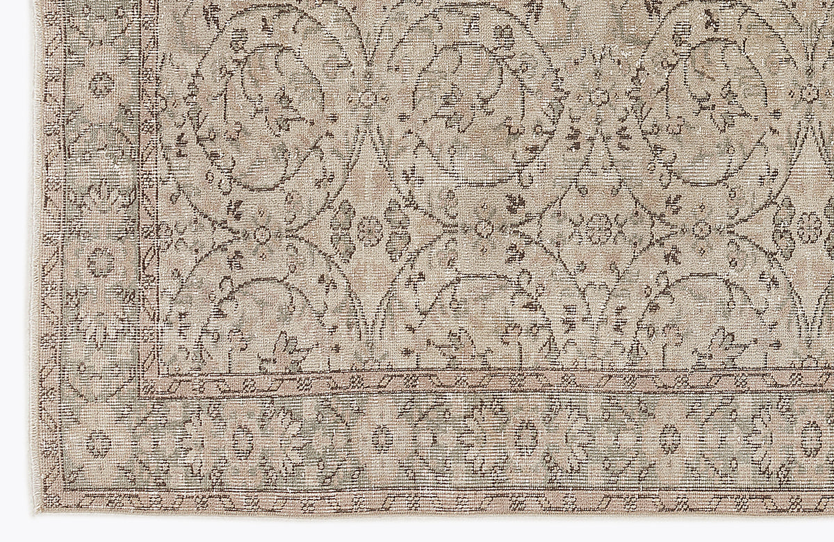 Beige and taupe traditional rug with a distressed floral medallion pattern and a detailed border.