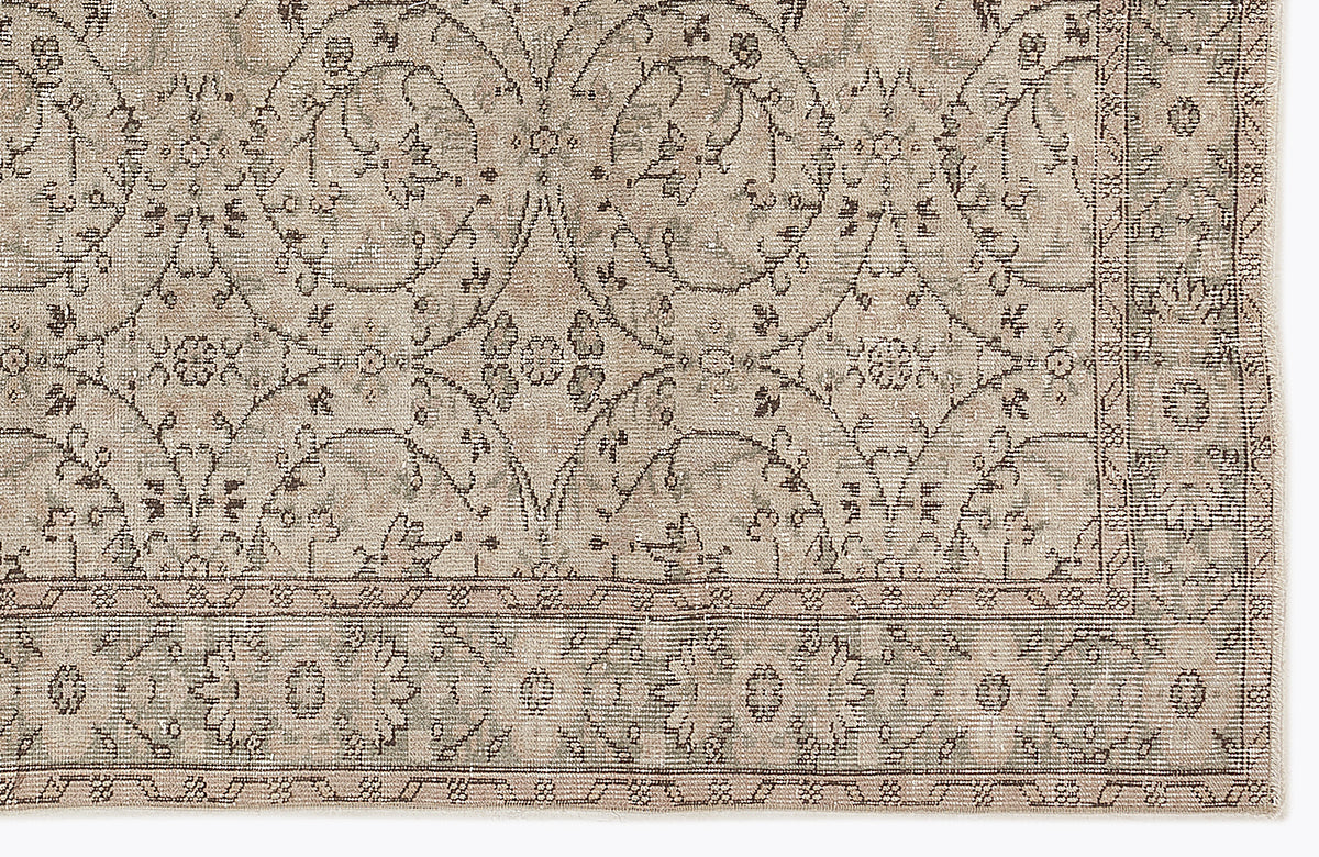 Beige and taupe traditional rug with a distressed floral medallion pattern and a detailed border.