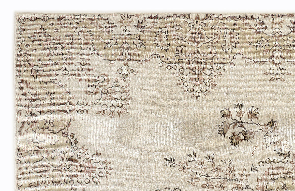 Beige and taupe traditional rug with a distressed floral medallion pattern on a white background.
