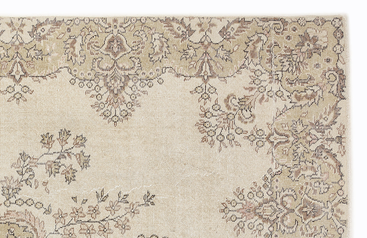 Beige and taupe rug with a distressed traditional floral medallion pattern on a white background.