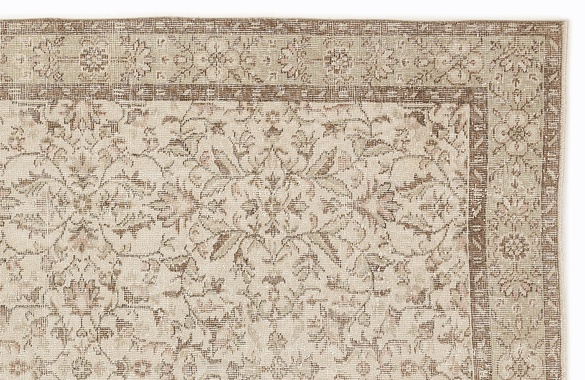 Beige and brown traditional rug with a distressed floral medallion pattern and a detailed border.