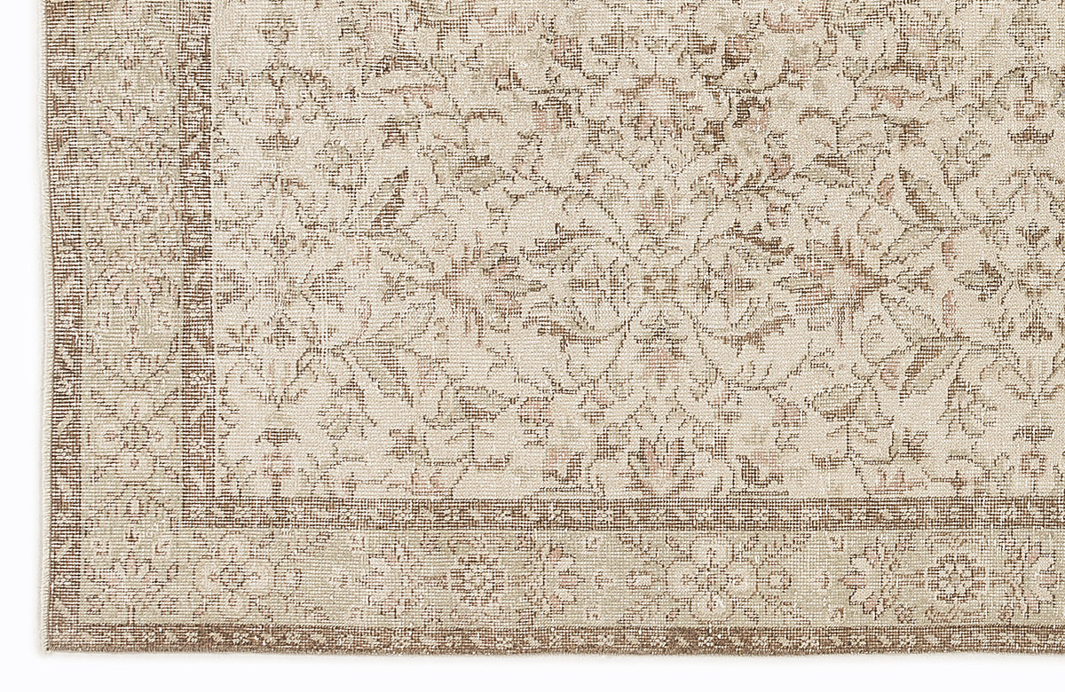 Beige and taupe rug with a traditional floral medallion pattern and a detailed border.