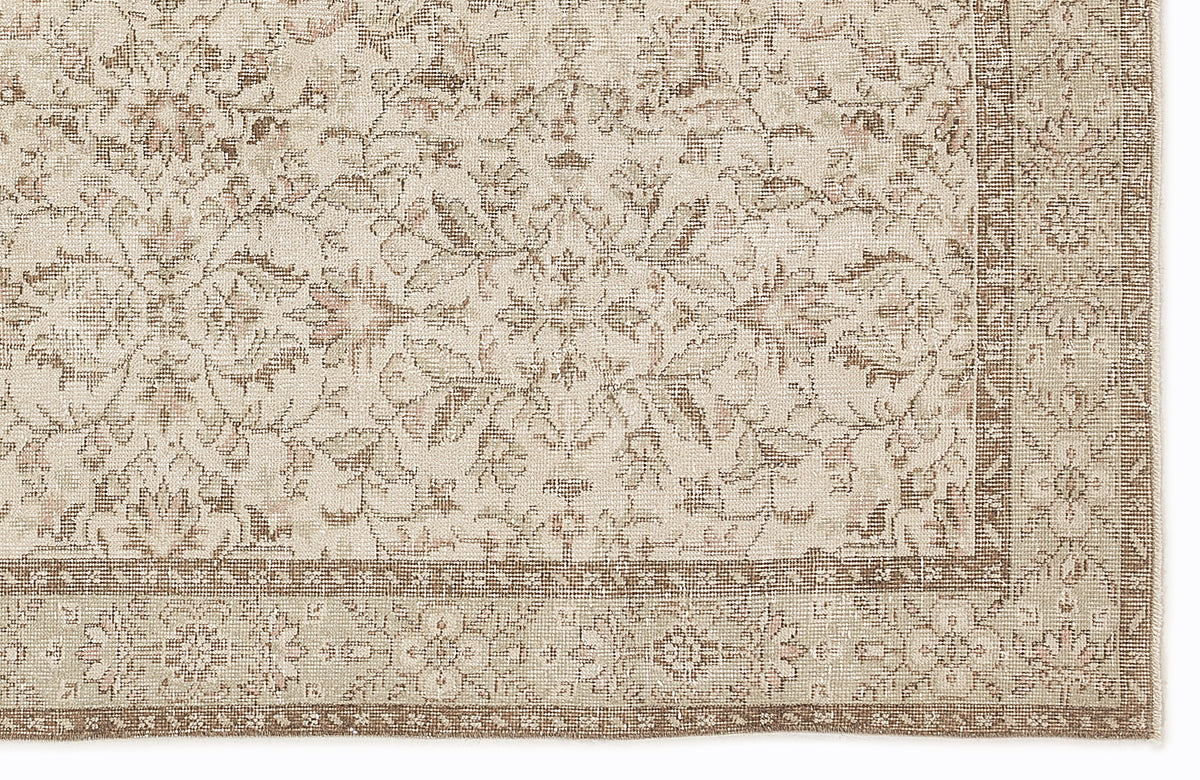 Beige and taupe traditional rug with a distressed floral medallion pattern and a detailed border.