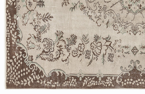Load image 1 in gallery view. Beige and brown rug with a distressed floral medallion pattern and sage green accents.