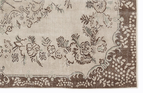 Load image 1 in gallery view. Beige and brown rug with a distressed floral medallion pattern and a wide decorative border.