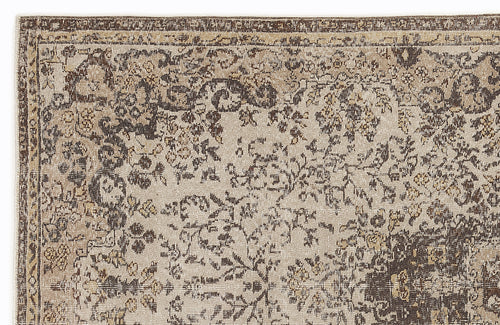 Load image 1 in gallery view. Beige and dark brown rug with a distressed, traditional floral pattern and a bordered edge.