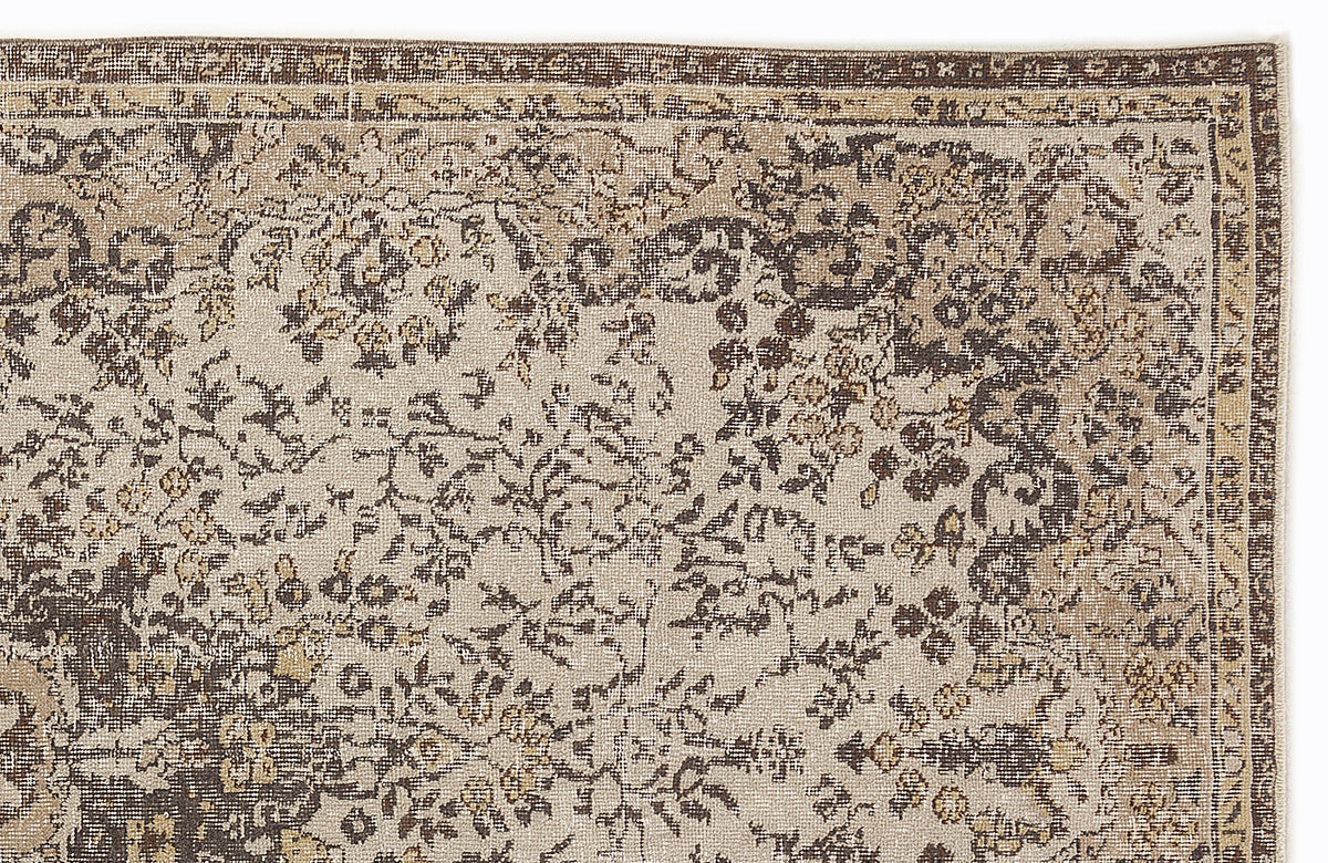Beige and dark brown rug with a distressed traditional floral pattern and a decorative border.