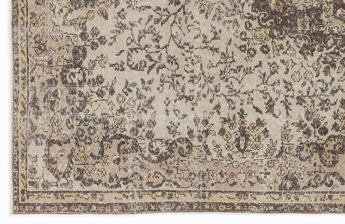 Beige and dark brown rug with a distressed, traditional floral medallion pattern and a bordered edge.